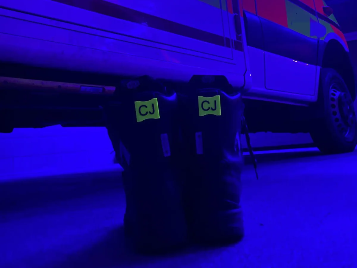 Einsatzstiefel mit Schuhclips vor einem Rettungswagen im Blaulicht