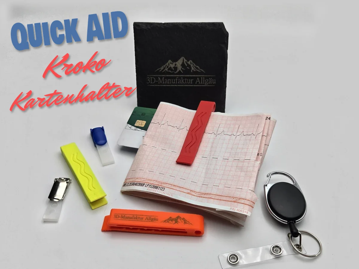 QuickAid Kroko Kartenhalter in Rot an einem EKG-Ausdruck, daneben Kartenhalter in Neon Gelb und in Neon Orange mit Gravur, Clips, Jojo und eine Gesundheitskarte