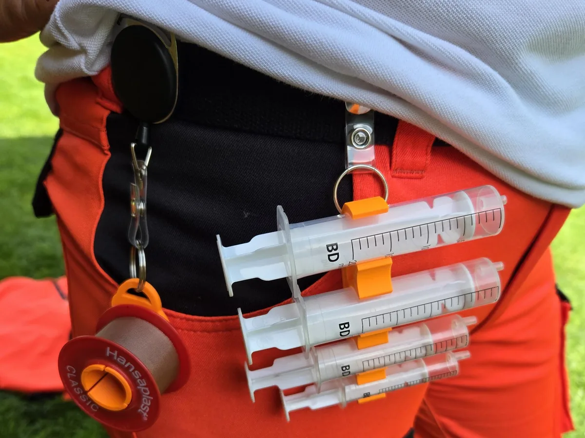 Oranger Spritzenhalter 1.0 mit Spritzen am ausziehbaren Clip an einer Rettungsdienst-Einsatzhose