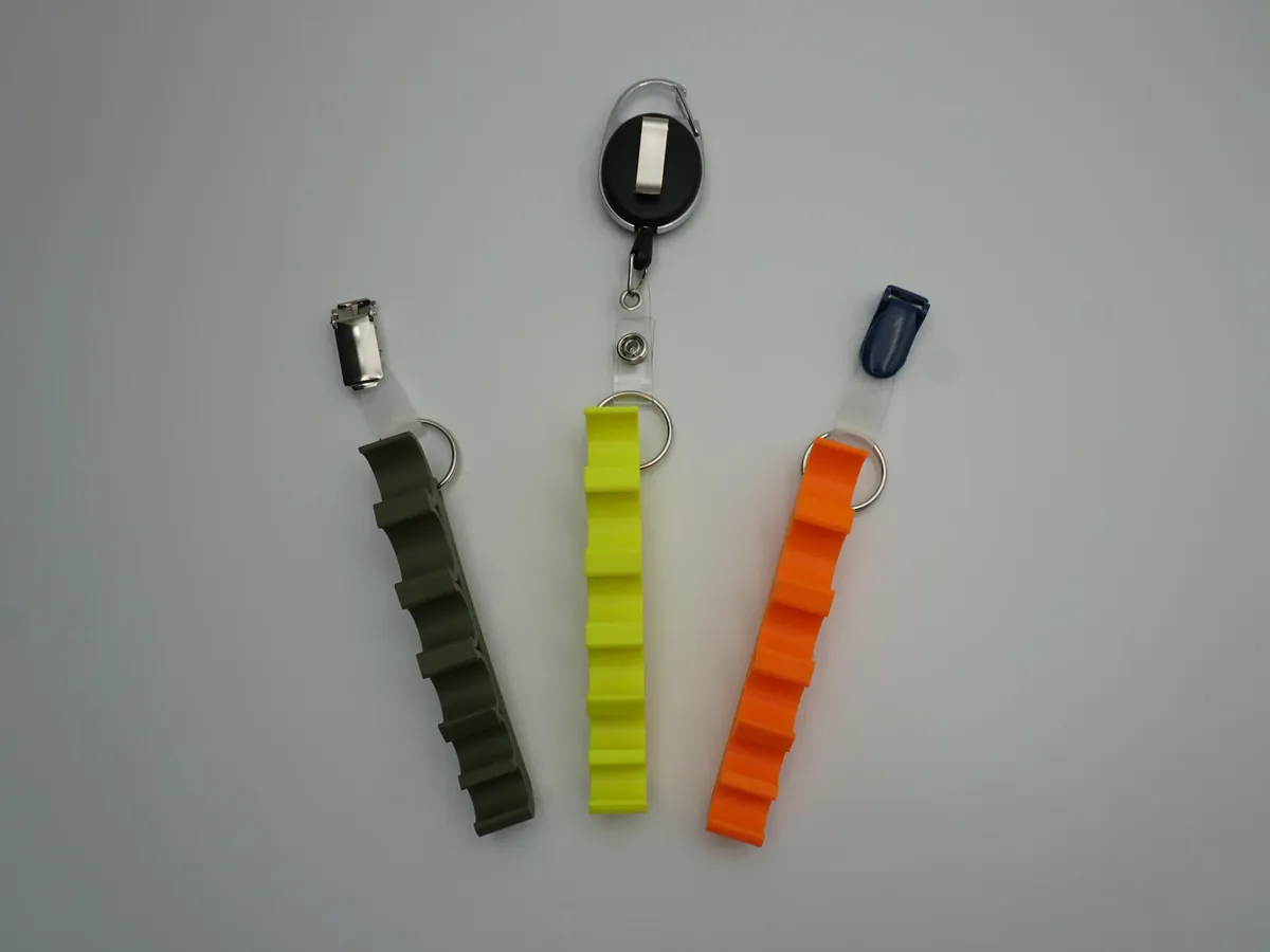 Drei Spritzenhalter 2.0 in Olivgrün, Neon Gelb und Neon Orange mit silbernem Clip, ausziehbarem Clip und blauem Clip